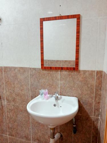 a bathroom with a sink and a mirror at HOTEL SAHARA INN TANJUNG MALIM in Kampong Chabang