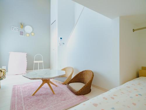 een kamer met een tafel en stoelen en een bed bij YOUR ROOM Kumamoto Sta little 203 Vacation STAY 75726 in Kumamoto