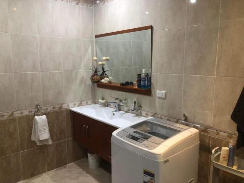 a bathroom with a sink and a mirror and a washing machine at Apartman Andalusie in Hurghada