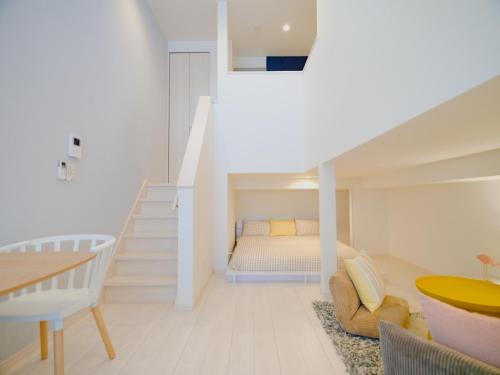 a white room with a bed and a staircase at YOUR ROOM Kumamoto Sta little 101 Vacation STAY 73968v in Kumamoto