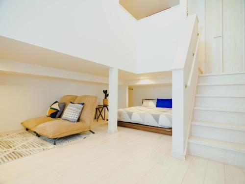 熊本市にあるYOUR ROOM Kumamoto Sta little 105 Vacation STAY 39911のベッドルーム1室(ベッド1台、椅子、階段付)