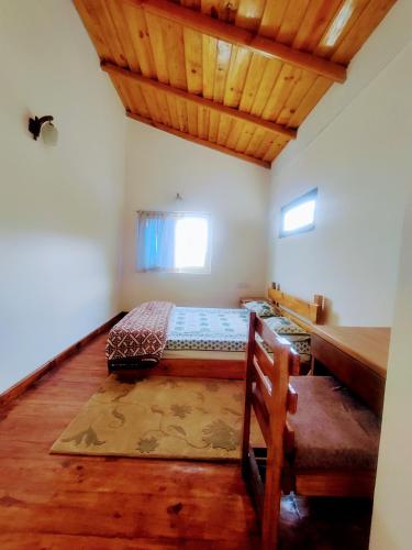 a bedroom with a bed and a wooden ceiling at Oakakhi Stays, Deluxe room in Rānīkhet