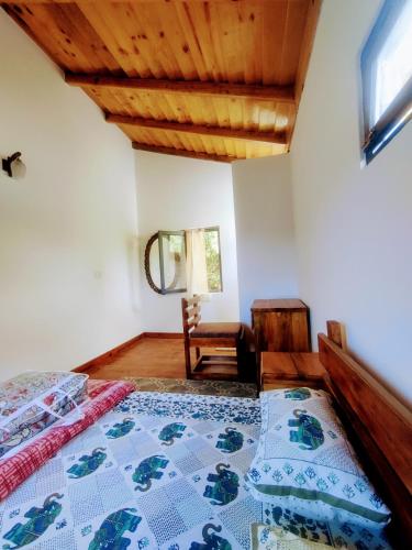 a bedroom with a bed and a wooden ceiling at Oakakhi Stays, Deluxe room in Rānīkhet