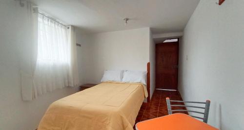 Kleines Zimmer mit einem Bett und einem Fenster in der Unterkunft Oro Verde Hostal in Cusco