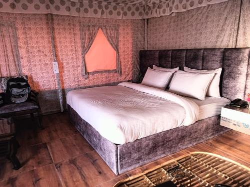 ein Schlafzimmer mit einem großen Bett in einem Zimmer in der Unterkunft Pulastya Wellness Resort in Saharanpur