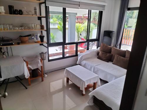 una sala de estar con un sofá y una mesa en บ้านบัวหลวงกันตังเมืองเก่า, en Ban Laem Muang