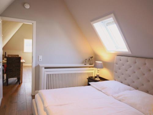 韋斯特蘭的住宿－Bundiswung 9 Whg. 5, GB2，一间卧室配有一张床和天窗