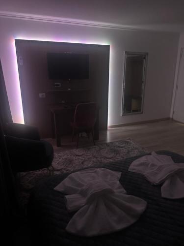 Habitación oscura con cama y TV. en Pensiunea Cascada Putnei, en Lepşa