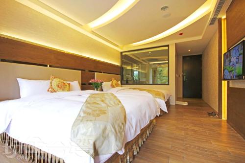 a bedroom with two beds and a large mirror at Shuian Lakeside Hotel in Yuchi
