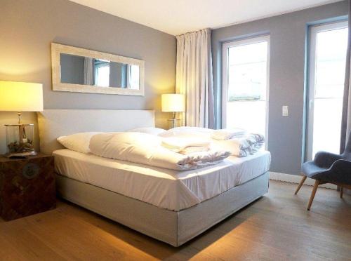 una camera da letto con un letto con lenzuola bianche e una finestra di Bomhoffstr. 17, W21, Penthouse, 2OG a Westerland