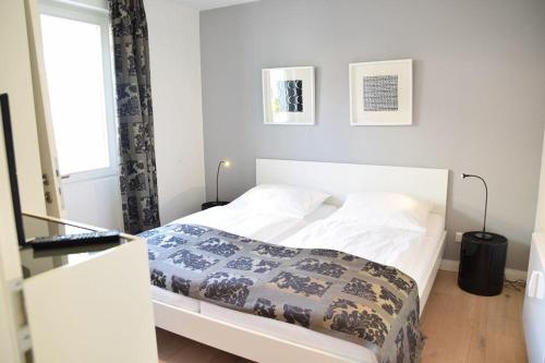 uma cama branca num quarto com uma janela em Bomhoffstr. 22a, W4, Blue Water em Westerland
