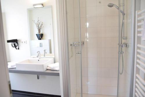 uma casa de banho com um lavatório e um chuveiro em Bomhoffstr. 22a, W4, Blue Water em Westerland