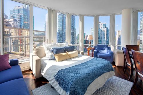 een slaapkamer met een bed en uitzicht op de stad bij Breathtaking Downtown Condo with Stunning Harbor Views! in Vancouver