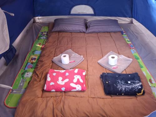 a bed in a tent with towels and pillows on it at Two Rocks Bungalows in Baan Tai