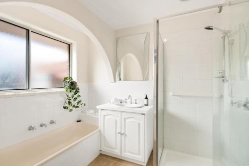 y baño blanco con lavabo y ducha. en Parkview by Short & Long Stays en Geelong
