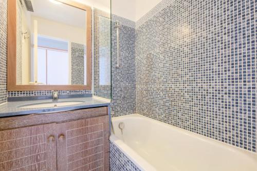 une salle de bain avec une baignoire, un lavabo et un miroir dans l'établissement Résidence le Hameau de Cap Esterel - maeva Home - Appartement 2 Pièces 5 Personnes - Confort MAE-2130, à Saint-Raphaël