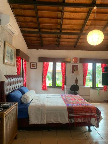 a bedroom with a large bed with red curtains at Taverno Villa in Serang