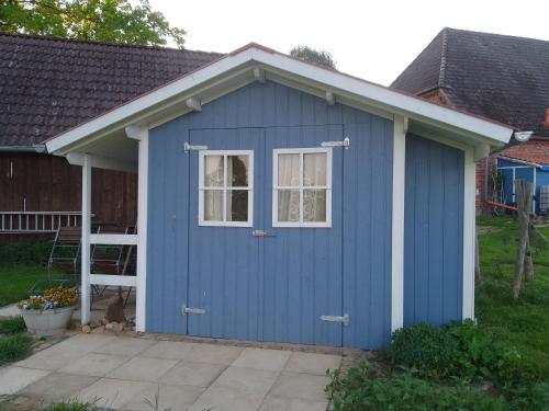 un cobertizo azul con una ventana y una puerta en Hütte Krötenhof, Radfahrer Übernachtung, en Barförde