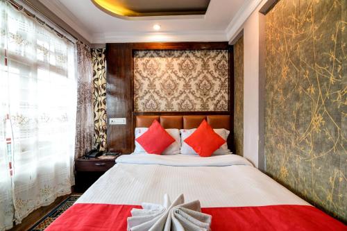 a bedroom with a large bed with red pillows at Hotel Kasturi Palace Darjeeling - Excellent Service Recommended in Darjeeling
