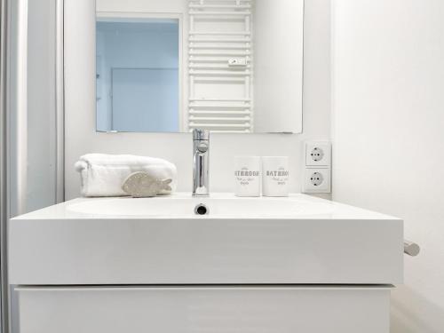 uma casa de banho com um lavatório branco e um espelho. em Nordmarkstraße 20, W21 Gestrandet em Westerland