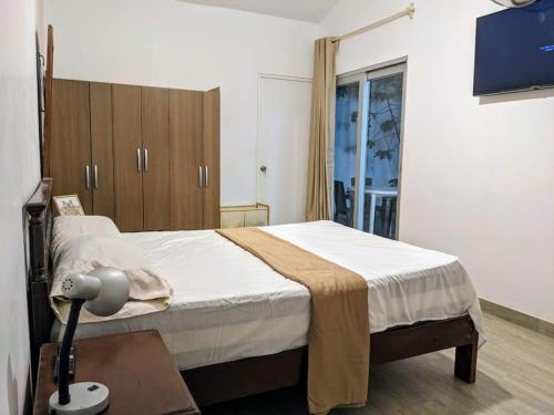 a bedroom with a bed and a desk with a lamp at Casa Selva Viva in Tarapoto