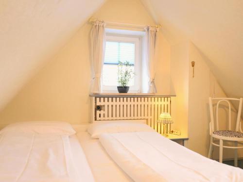ヴェスターラントにあるHoogenkamp 19c, DGのベッドルーム1室(ベッド1台付)、植物のある窓が備わります。
