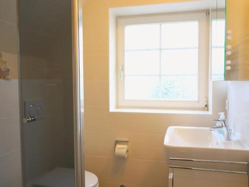 ヴェスターラントにあるHoogenkamp 19c, DGのバスルーム(洗面台、トイレ付)、窓が備わります。