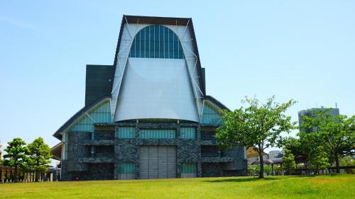 a building with a large window on top of a field at Toyoko Inn Shizuoka eki Minami guchi in Shizuoka