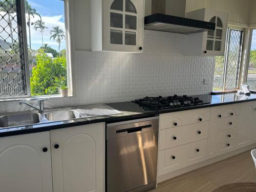 a kitchen with white cabinets and a stove top oven at 3 bed room house near airport in North Ward