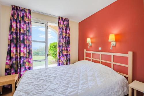 une chambre avec un lit et une grande fenêtre dans l'établissement Résidence le Village de Cap Esterel - maeva Home - Appartement 2 Pièces 5 Personnes - Sélection MAE-1765, à Saint-Raphaël