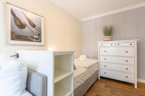 um quarto com uma cama e uma cómoda em Strandstraße 6 Whg. 21 em Westerland