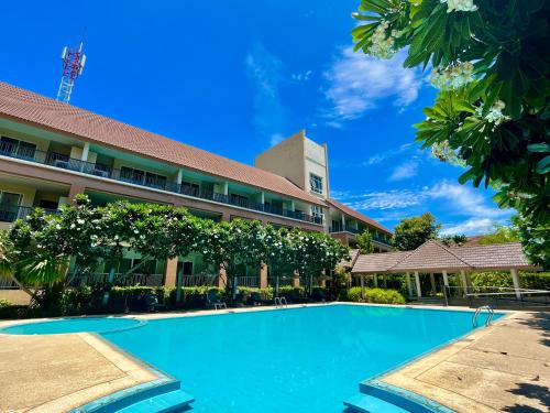 a swimming pool in front of a building at Authong Residence in North Pattaya