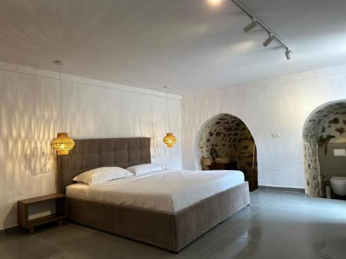 a bedroom with a large bed and two arches at LION'S VILLA in Vlorë