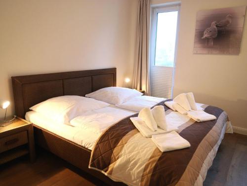 una camera da letto con un letto e asciugamani di Brandenburger Straße 5b, Whg.6 a Westerland