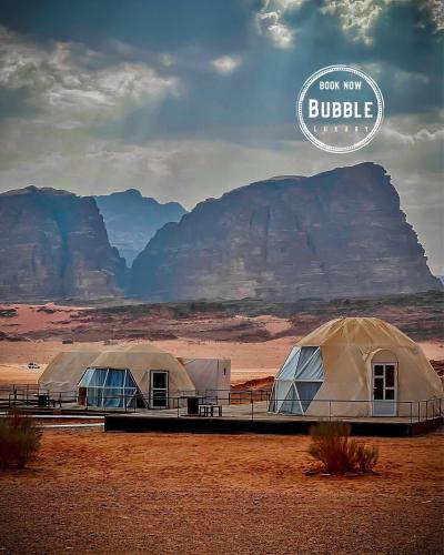 two domes in the desert with mountains in the background at Wadi rum Bubble luxury camp in Wadi Rum