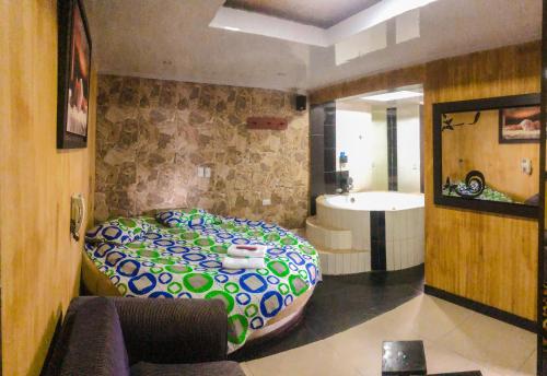 Habitación con cama y bañera. en Hotel Residencial Olaya Plaza, en Manizales