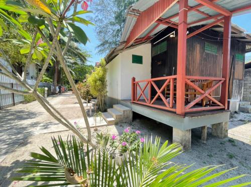 a building with a porch and some plants and flowers at B'first Chalet Perhentian Island in Kuala Besut