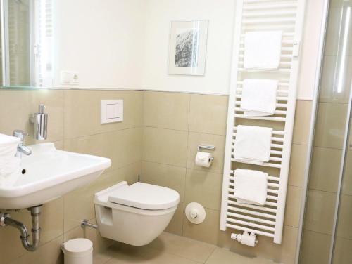 Łazienka z białą toaletą i umywalką w obiekcie Miit Liebe zum Detail eingerichtete 2-Zimmer-Ferienwohnung im Zentraum von Westerland w mieście Westerland