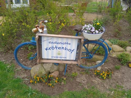a sign for a garden with a bike with a basket at Hütte Krötenhof, Radfahrer Übernachtung in Barförde