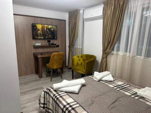 1 dormitorio con cama, escritorio y silla en Pensiunea Cascada Putnei, en Lepşa