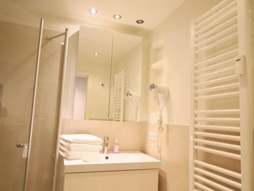 ein Bad mit einem Waschbecken, einer Dusche und einem Spiegel in der Unterkunft Ferienhaus mit neuen und sehr hochwertigen Appartements in zentraler Lage in Westerland in Westerland
