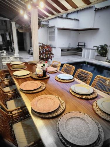 a long wooden table with plates on top of it at Hermosa casa en Cauca Viejo in Jericó
