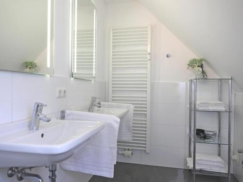 ein Badezimmer mit einem Waschbecken, einem Spiegel und Handtüchern in der Unterkunft Ferienhaus mit neuen und sehr hochwertigen Appartements in zentraler Lage in Westerland in Westerland