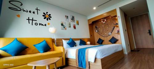 a bedroom with a bed and a couch at Flamingo Ibiza Hai Tien in Nam Khê