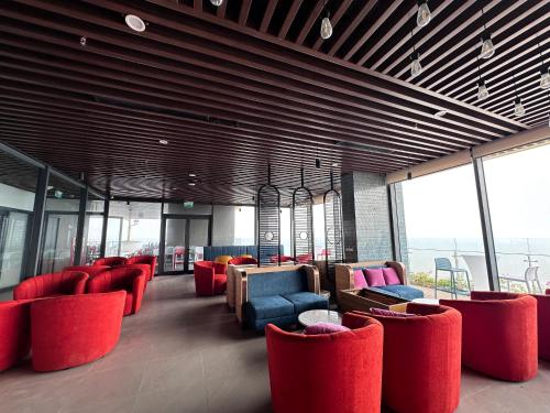 a lobby with red chairs and tables and windows at Flamingo1 Ibiza Hai Tien in Nam Khê