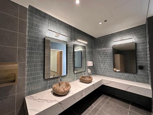La salle de bains est pourvue de 2 lavabos et de 2 miroirs. dans l'établissement Flamingo Ibiza Hai Tien, à Nam Khê