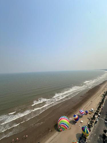 an aerial view of a beach with umbrellas and crowds at Flamingo1 Ibiza Hai Tien in Nam Khê
