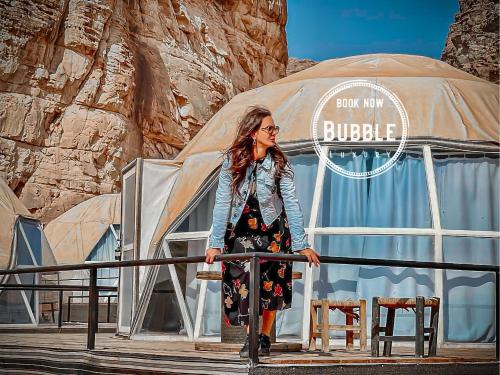 a woman is standing in front of a yurt at Wadi rum Bubble luxury camp in Wadi Rum