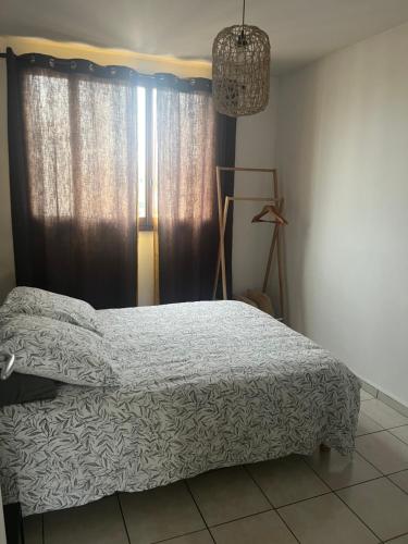 1 dormitorio con cama y ventana en Appart T3 proche métro -draps et serviettes inclus, en Marsella