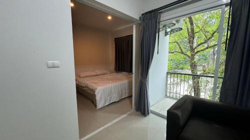 a bedroom with a bed and a balcony with a window at Phuket naka condon-52-45 免费高速上网免费停车 in Phuket